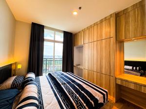 - une chambre avec un lit et une grande fenêtre dans l'établissement PREMIER RESIDENCES @Formosa Residence Nagoya, à Nagoya
