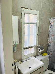 un bagno con lavandino, WC e finestra di Dpto. céntrico San Lucas a Río Cuarto