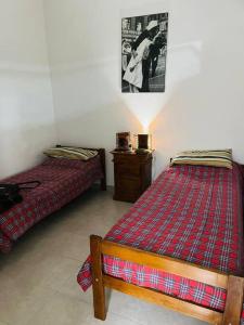 una camera da letto con due letti e un tavolo con una lampada di Dpto. céntrico San Lucas a Río Cuarto