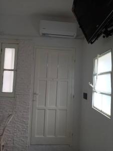 porta bianca in camera con due finestre di Dpto. céntrico San Lucas a Río Cuarto