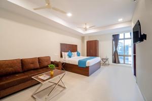 a living room with a bed and a couch at Monday Hotels Swarna's The Capital in Vijayawāda