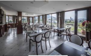 un restaurante con mesas, sillas y ventanas en Hotel Europe plaza en Tiflis