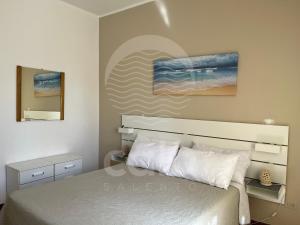 トッレ・ラピッロにあるBella Vita - Piano Primoのベッドルーム1室(ベッド1台付)が備わります。壁には絵画が飾られています。