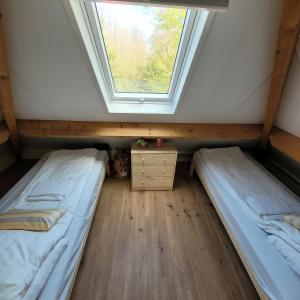 two beds in a room with a window at Ecolodges De Dreef Guesthouse in Renesse
