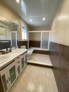 a large bathroom with two sinks and a toilet at CAN TRULLEN CHALET CALAFELL in Calafell