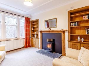 a living room with a fireplace and a tv at 6 Bed in Lairg CA210 