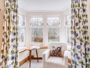 a living room with a chair and windows at 6 Bed in Lairg CA210 