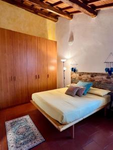 - une chambre avec un grand lit et des placards en bois dans l'établissement Casa al Campanile Tameró HolyDay Apartments, à Bocchignano