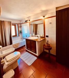 La salle de bains est pourvue d'un lavabo, de toilettes et d'une baignoire. dans l'établissement Casa al Campanile Tameró HolyDay Apartments, à Bocchignano
