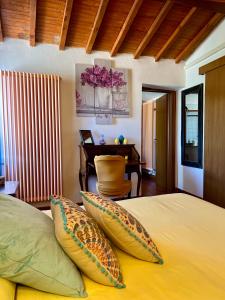 - une chambre avec un lit avec des oreillers et un bureau dans l'établissement Casa al Campanile Tameró HolyDay Apartments, à Bocchignano