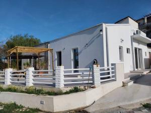 a white building with a porch and a fence at Casa Plemmirio Varco 22 in Plemmirio +11 photos