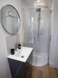 a bathroom with a sink and a shower with a mirror at Green Nest Room with private bathroom in Eastbourne