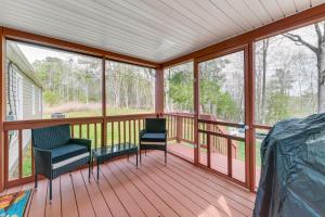 un porche cubierto con 2 sillas y ventanas en Toano Home with Screened Porch Steps to Lake!, en Croaker