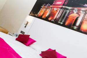 Habitación de hotel con cama con almohadas rojas en CH Olmedo, en Madrid