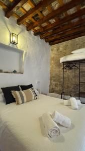 1 dormitorio con 1 cama con 2 toallas en Apartamentos Jerez Siglo XIX, en Jerez de la Frontera