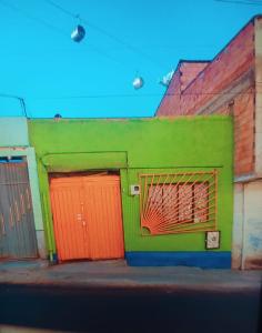 un edificio verde y naranja con dos puertas naranjas en Casa familiar orange corner, en La Paz