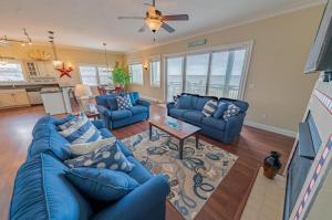 a living room with blue couches and a table at RSR2A - Endless Sunsets in Rodanthe