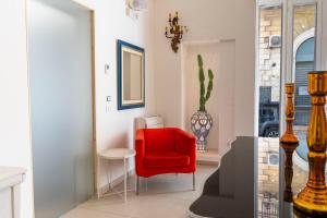 una sedia rossa in una stanza con finestra di Palazzo Cavour a Lecce