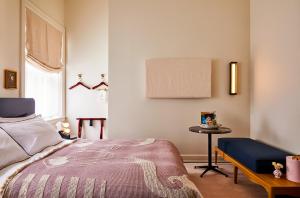 Un dormitorio con una cama y una mesa. en The Siren Hotel en Detroit