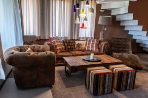 a living room with a couch and two chairs and a table at Martini villa Lake in Razlog