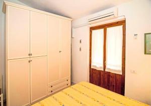 a bedroom with a bed and cabinets and a window at Casa Podda in San Teodoro