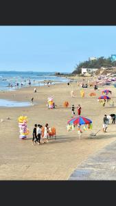 a group of people on a beach with umbrellas at Hotel Minh Thắng in Vung Tau