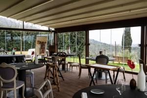ein Restaurant mit Tischen und Stühlen und großen Fenstern in der Unterkunft Locanda De Banchieri in Fosdinovo