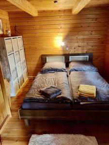 Un pat sau paturi într-o cameră la FEWO PARTNERS Haus Clemens - Gemütliches Holzhaus mit Grundstück nahe Badesee