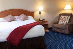 Habitación de hotel con cama y silla en Hotel Glenwood Springs, en Glenwood Springs