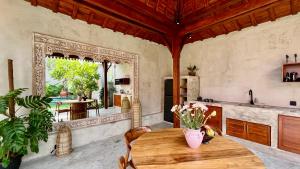 a kitchen with a wooden table in a room at Jabunami Villa in Canggu