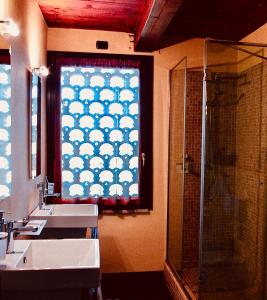a bathroom with two sinks and a window with a shower at Podere Boschetto R&B in Bologna