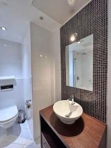 ein Badezimmer mit einem Waschbecken, einem WC und einem Spiegel in der Unterkunft Cathedral Quarter Hotel - Derby in Derby