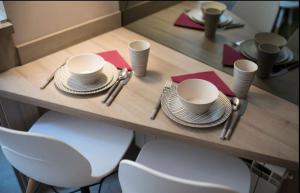 a table with plates and utensils on top of it at The Empress apartment Belgrade in Belgrade