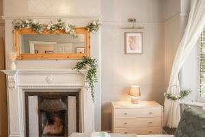 a living room with a fireplace and a mirror at Spacious 4 bed Edwardian home in Chester - Sleeps up to 7 in Chester +21 photos
