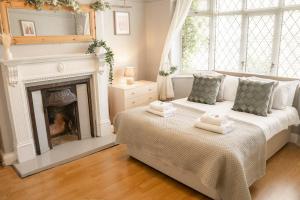 two beds in a room with a fireplace at Spacious 4 bed Edwardian home in Chester - Sleeps up to 7 in Chester