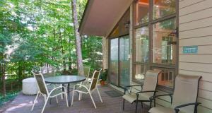 a screened in porch with a table and chairs at Shady Woods Cabin in Gatlinburg