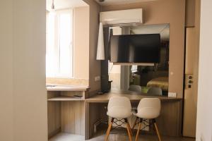 a room with a desk with two chairs and a television at The Empress apartment Belgrade in Belgrade
