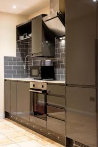 a kitchen with a stove and a microwave at Cosy Apartment In The Heart of the City in Norwich