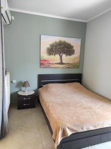 sypialnia z obrazem drzewa na ścianie w obiekcie Spartacus Apartment w Aleksandropolis