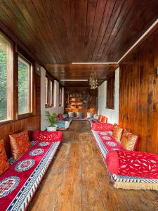 salon z czerwonymi kanapami i drewnianą podłogą w obiekcie Aarya homes w mieście Manāli