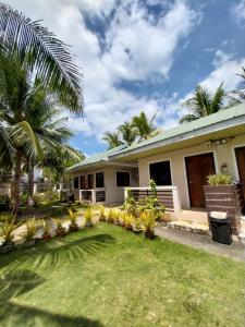 a house with palm trees in front of it at TAVERN ROOMS FOR RENT in Panglao