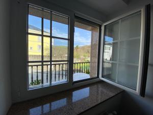 a room with two windows with a view of a balcony at Habitaciones A Casa de Pepe in Tríacastela