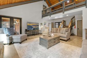 un salon avec un canapé et une table dans l'établissement Evergreen -LUXURY CABIN WITH A HOT TUB, GAME ROOM & 3 EN-SUITE BEDROOMS!, à Big Bear Lake