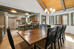 une cuisine et une salle à manger avec une table et des chaises en bois dans l'établissement Evergreen -LUXURY CABIN WITH A HOT TUB, GAME ROOM & 3 EN-SUITE BEDROOMS!, à Big Bear Lake