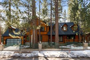 une maison dans les bois avec de la neige devant elle dans l'établissement Evergreen -LUXURY CABIN WITH A HOT TUB, GAME ROOM & 3 EN-SUITE BEDROOMS!, à Big Bear Lake