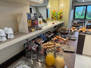 una colazione a buffet con cibi e bevande su un bancone di Ile Hotel a Peschiera del Garda