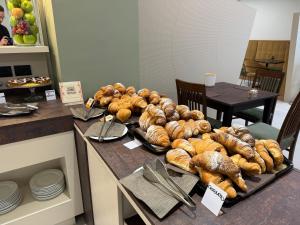 un tavolo ricoperto da molti tipi diversi di pane di Ile Hotel a Peschiera del Garda