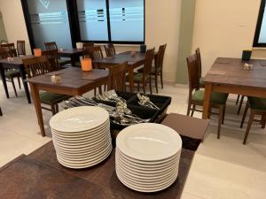 una sala da pranzo con tavoli, sedie e piatti bianchi di Ile Hotel a Peschiera del Garda
