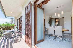 a room with a balcony with a table and chairs at House FELICIA in Kršan