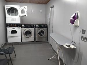a laundry room with three washing machines and a counter at The Drey in Grantown on Spey